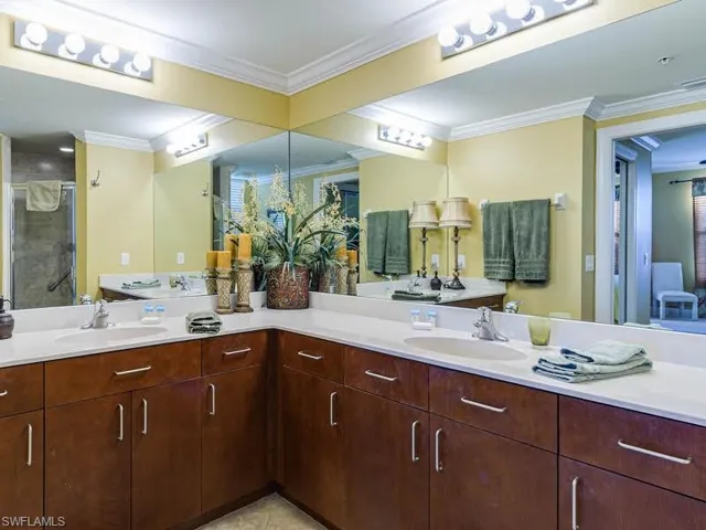 Full bath featuring double vanity, ornamental molding, a stall shower, and light tile patterned flooring