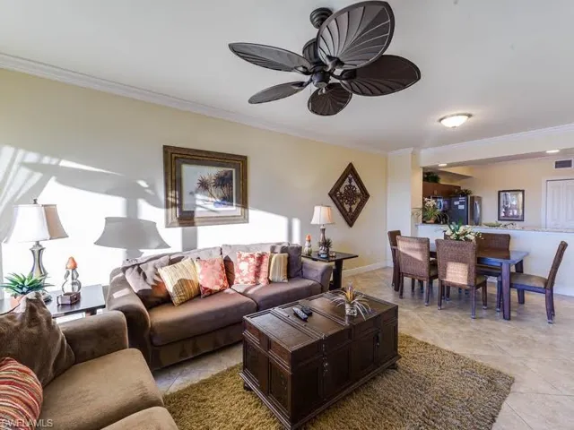 Living room with crown molding, a ceiling fan, and light tile patterned flooring