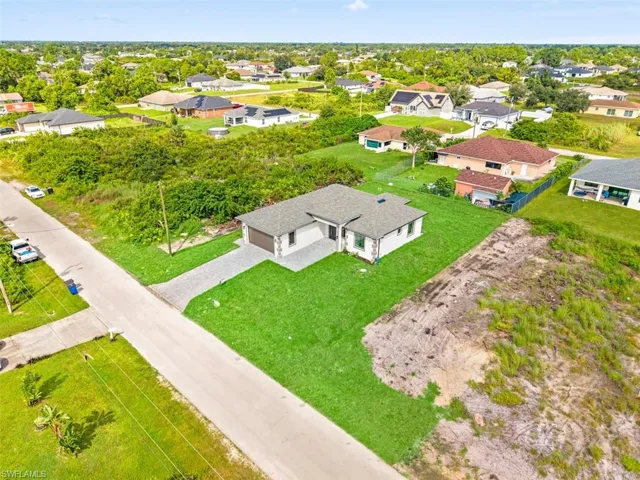 Single-story residence with an attached garage, featuring a paved driveway and a well-maintained lawn