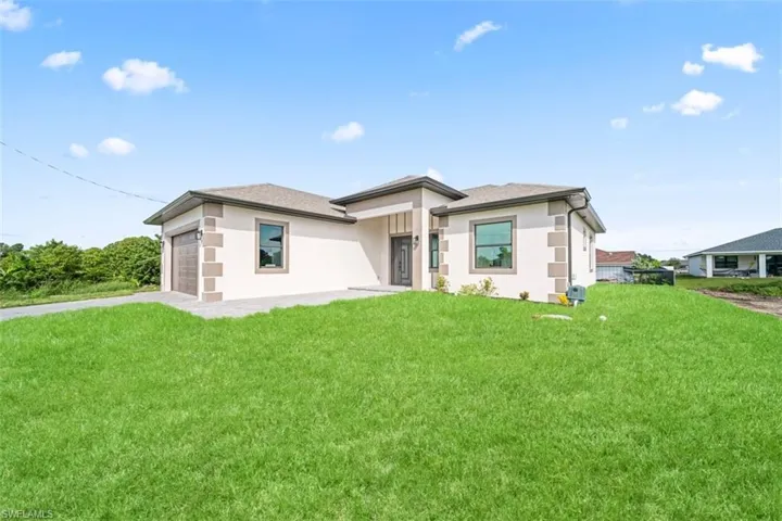 Contemporary single-story exterior with a stucco finish, stone detailing, and a shingle roof