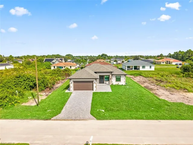 Contemporary single-story residence with a paved driveway, attached garage, and a gabled roof