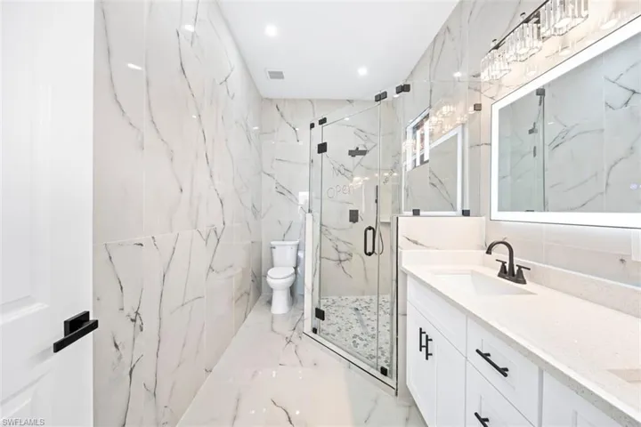 Full height tiled walls and flooring with a matching vanity backsplash