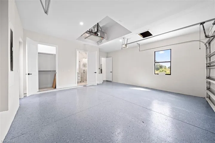 Epoxy garage flooring, recessed lighting, double doors, single window, and roll-up garage door