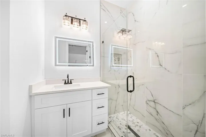 White vanity with a solid surface countertop and undermount sink