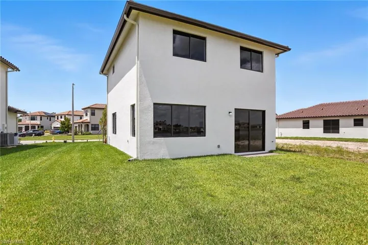 Back of house featuring a yard and stucco siding