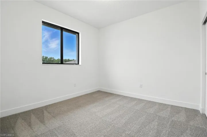 Carpeted empty room featuring baseboards
