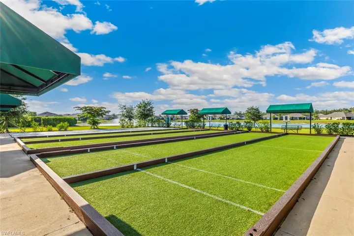 The property features bocce ball courts with artificial turf, bordered by concrete pathways