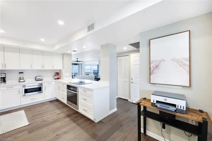 Kitchen featuring white cabinets, wood-type flooring, and appliances with stainless steel finishes