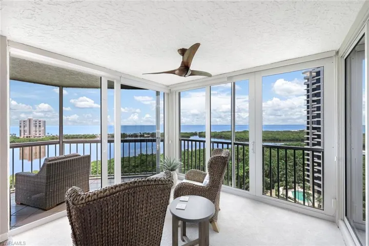 Sunroom with a water view and ceiling fan