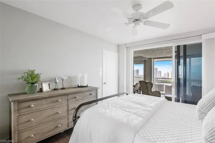 Bedroom with access to outside, dark hardwood / wood-style floors, and ceiling fan