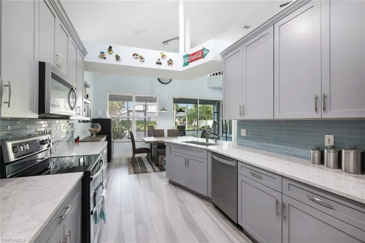 Kitchen features stainless steel appliances, shaker cabinets, and quartz countertops.
