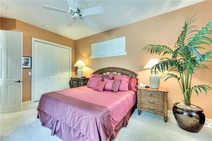 Bedroom featuring a closet, ceiling fan, and light colored carpet