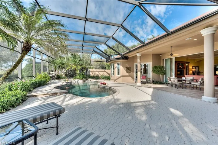 View of swimming pool featuring a patio area, ceiling fan, and glass enclosure