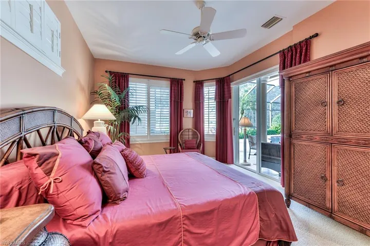 Bedroom with light colored carpet, ceiling fan, access to exterior, and multiple windows