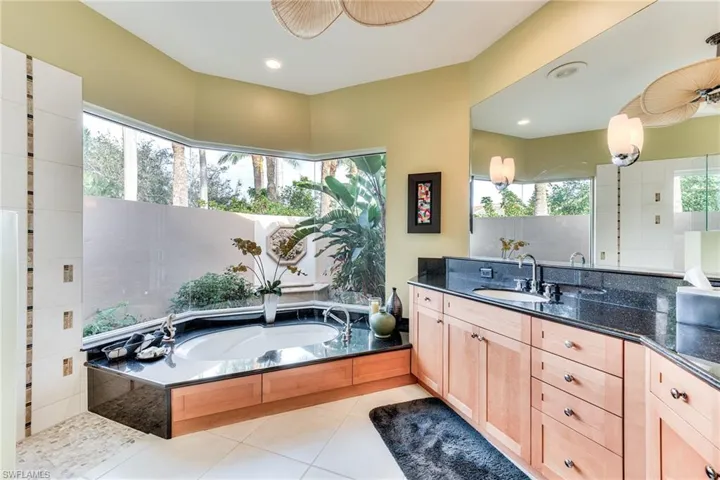 Bathroom featuring vanity, tile patterned floors, and plenty of natural light