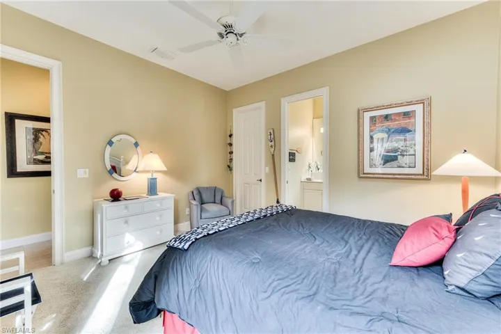 Bedroom featuring ensuite bathroom, ceiling fan, and carpet