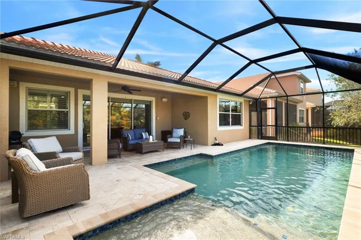 View of pool with ceiling fan, a patio, outdoor lounge area, and glass enclosure