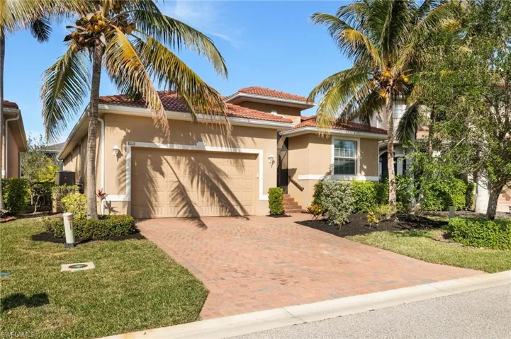 Mediterranean / spanish-style house with a garage and a front yard