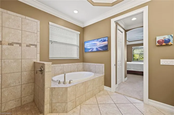 Bathroom featuring tile patterned flooring, ornamental molding, plus walk in shower, and ceiling fan