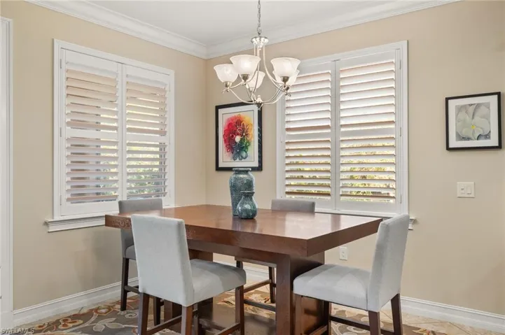 Dining room with ornamental molding and a chandelier