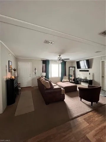 Living room with hardwood / wood-style floors, ornamental molding, and ceiling fan