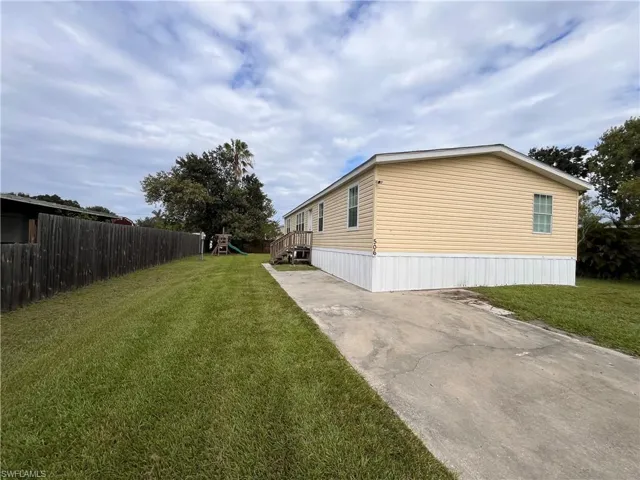 View of side of home with a playground and a lawn