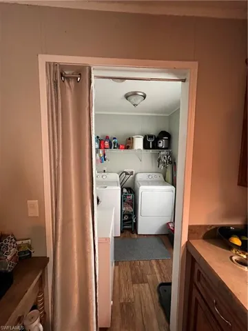 Laundry room featuring washing machine and dryer and hardwood / wood-style flooring