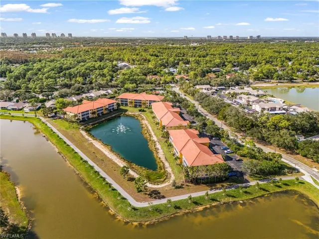 Bird's eye view of a large body of water and city skyline with walking trails