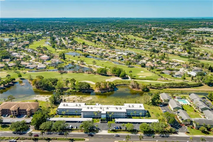 Drone / aerial view with view of golf course, a water view, and a residential view
