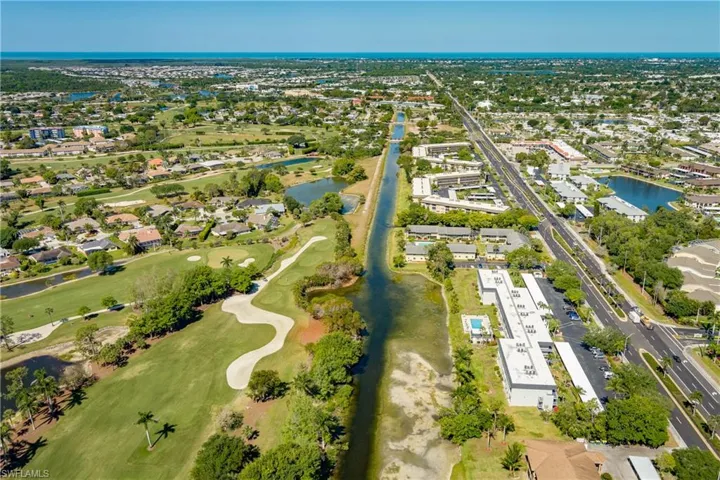 Birds eye view of property featuring view of golf course, a water view, and a residential view