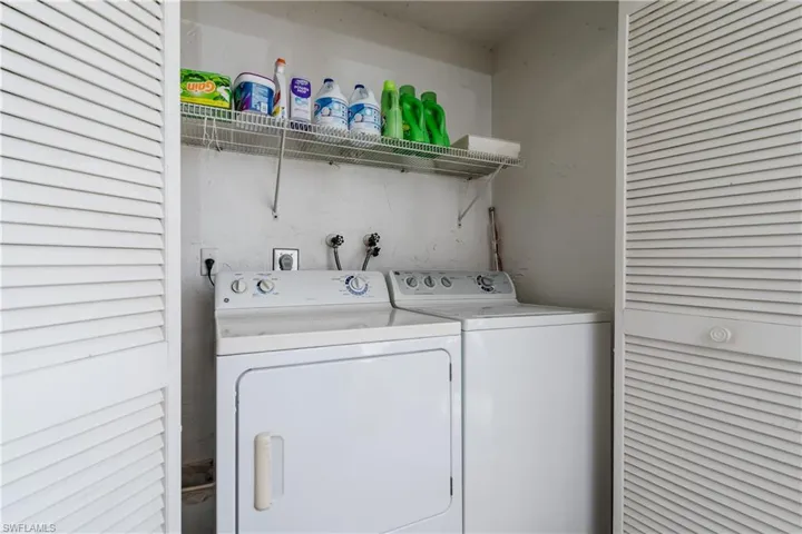 Washroom featuring laundry area and washer and clothes dryer