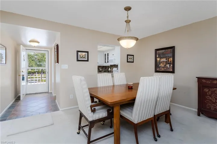 Dining room with baseboards and light colored carpet