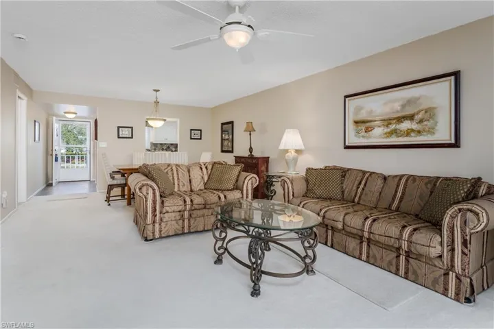Carpeted living room featuring ceiling fan