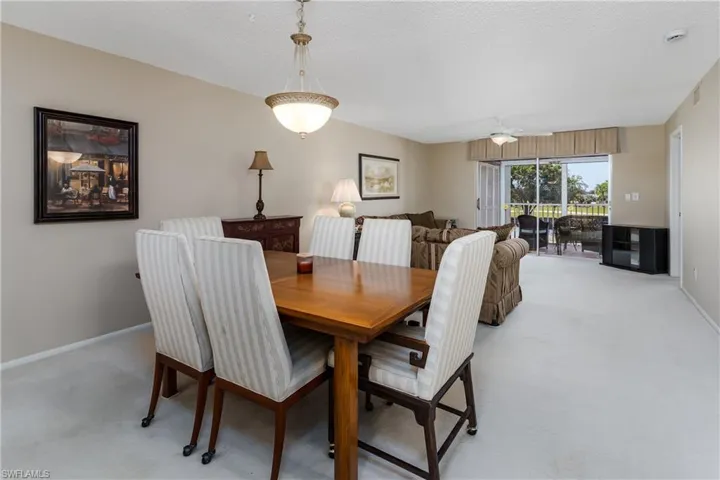 Dining space with ceiling fan, baseboards, visible vents, and light colored carpet