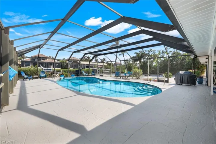 View of swimming pool with a lanai, grilling area, and a patio