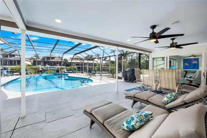 View of pool featuring ceiling fan, a grill, glass enclosure, and a patio