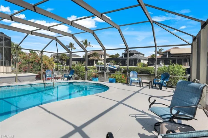 View of swimming pool with a patio and glass enclosure