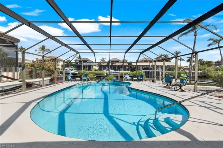 View of swimming pool featuring a patio and glass enclosure