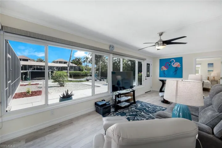 Living room with crown molding, ceiling fan, and light hardwood / wood-style floors