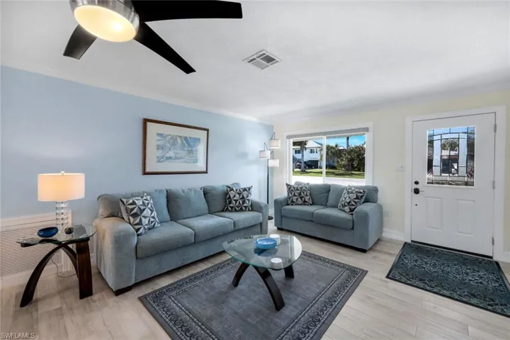 Living room with crown molding, light hardwood / wood-style flooring, and ceiling fan