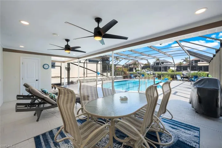 View of patio with a lanai, a grill, and ceiling fan
