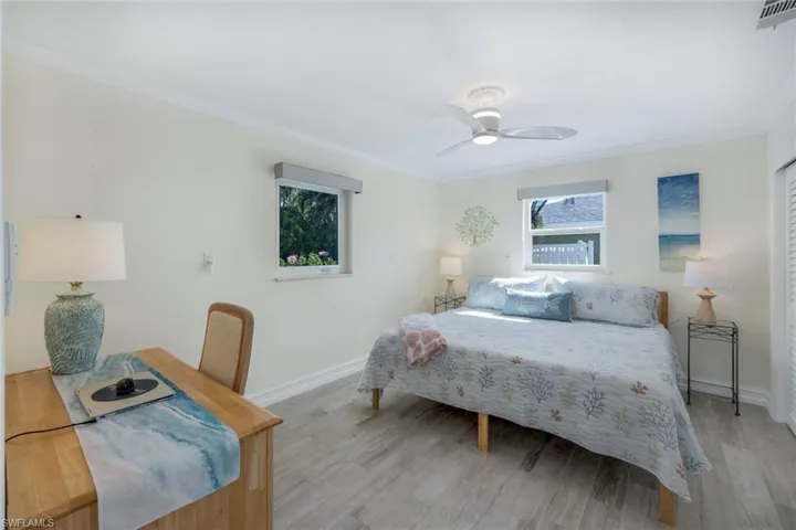 Bedroom with crown molding, ceiling fan, and light wood-type flooring