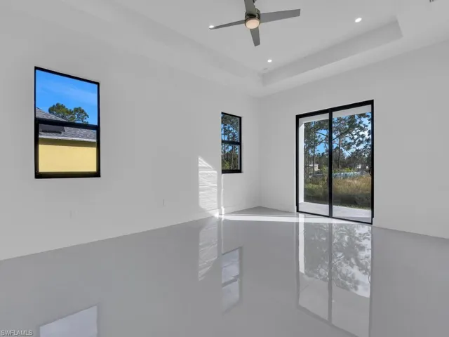 Unfurnished room with ceiling fan and a raised ceiling