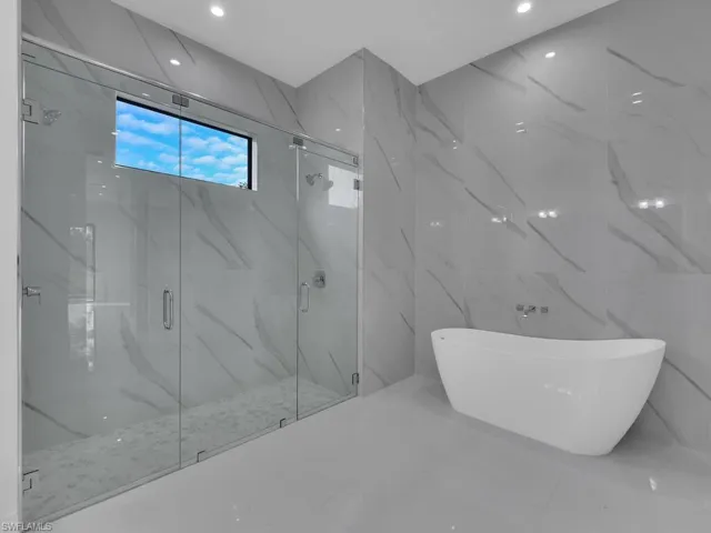 Bathroom featuring tile walls and independent shower and bath