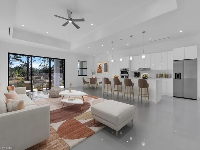 Tiled living room with a tray ceiling, ceiling fan, and ornamental molding, furnitures are not included.
