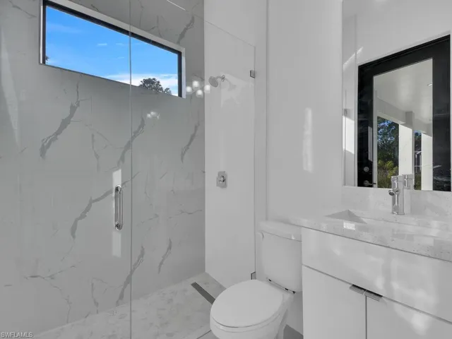 Bathroom # 2 with vanity, toilet, and a shower with shower door.