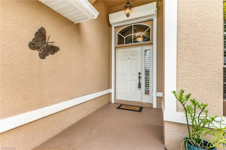 Front entry featuring a white paneled door with an arched transom window and sidelights