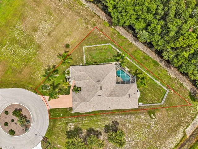 Aerial depiction of a property featuring a central residence with a screened pool enclosure and a paved driveway