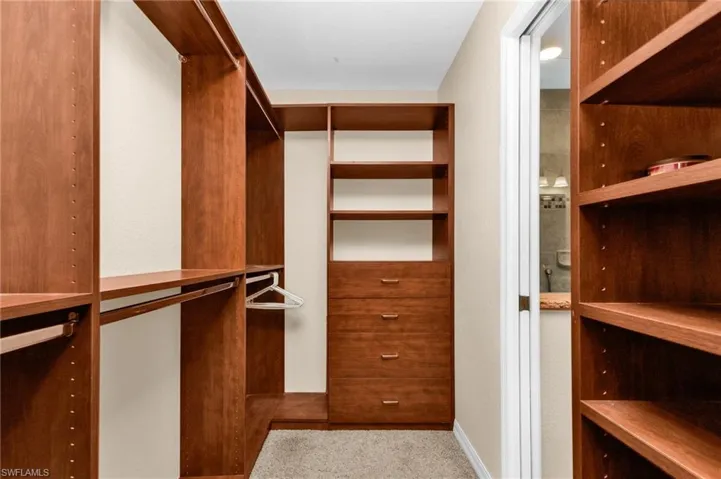 Custom closet system featuring rich wood-finish shelving and integrated drawer storage