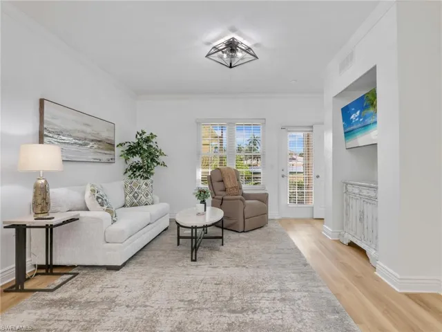 Living area with light wood finished floors and crown molding